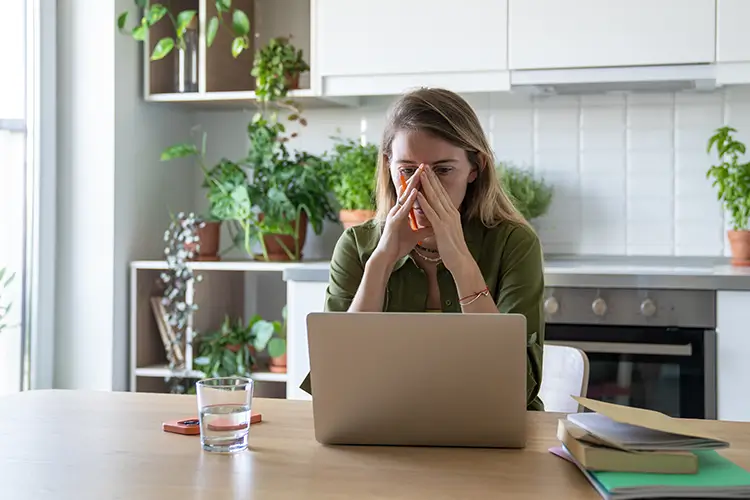 Overwhelmed woman staring at her laptop with stress