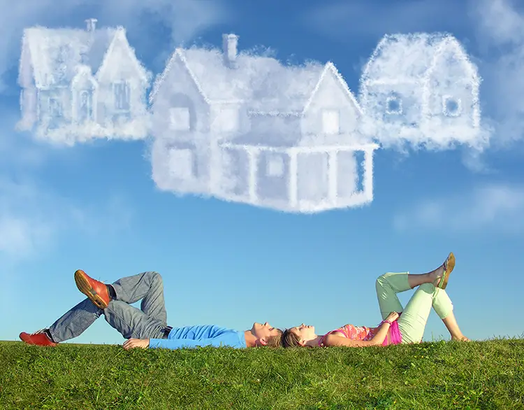 Couple laying on grass, dream up 3 houses from clouds above